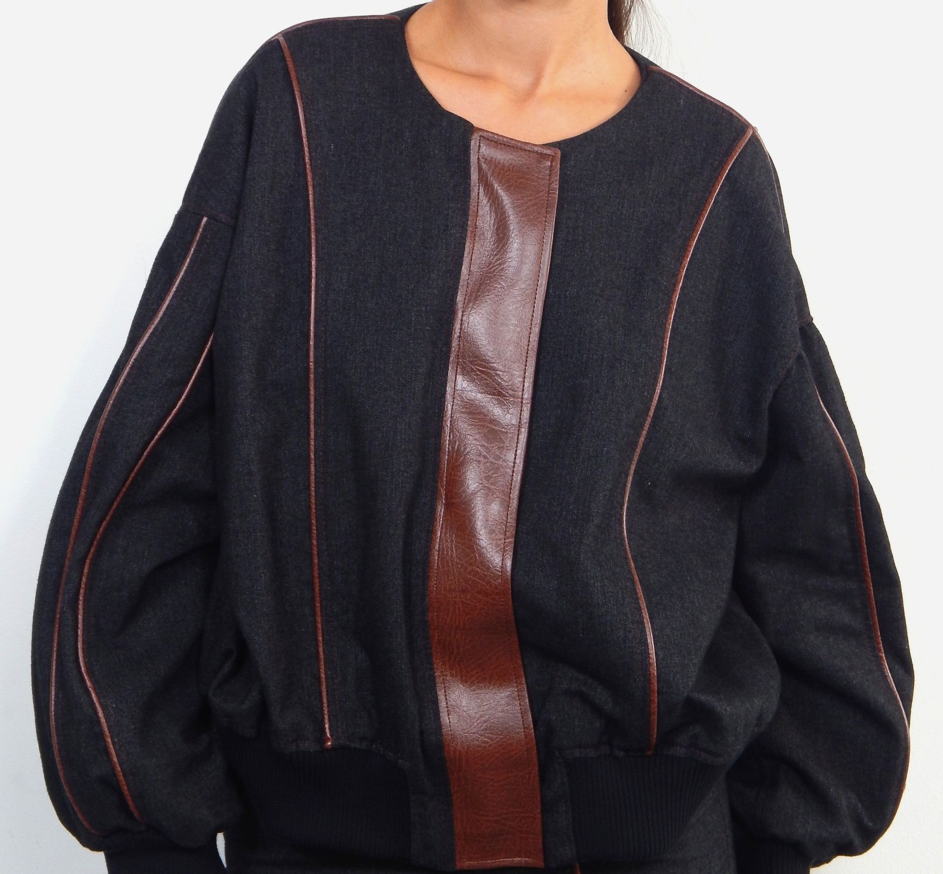 Black bomber jacket with brown leather accents.