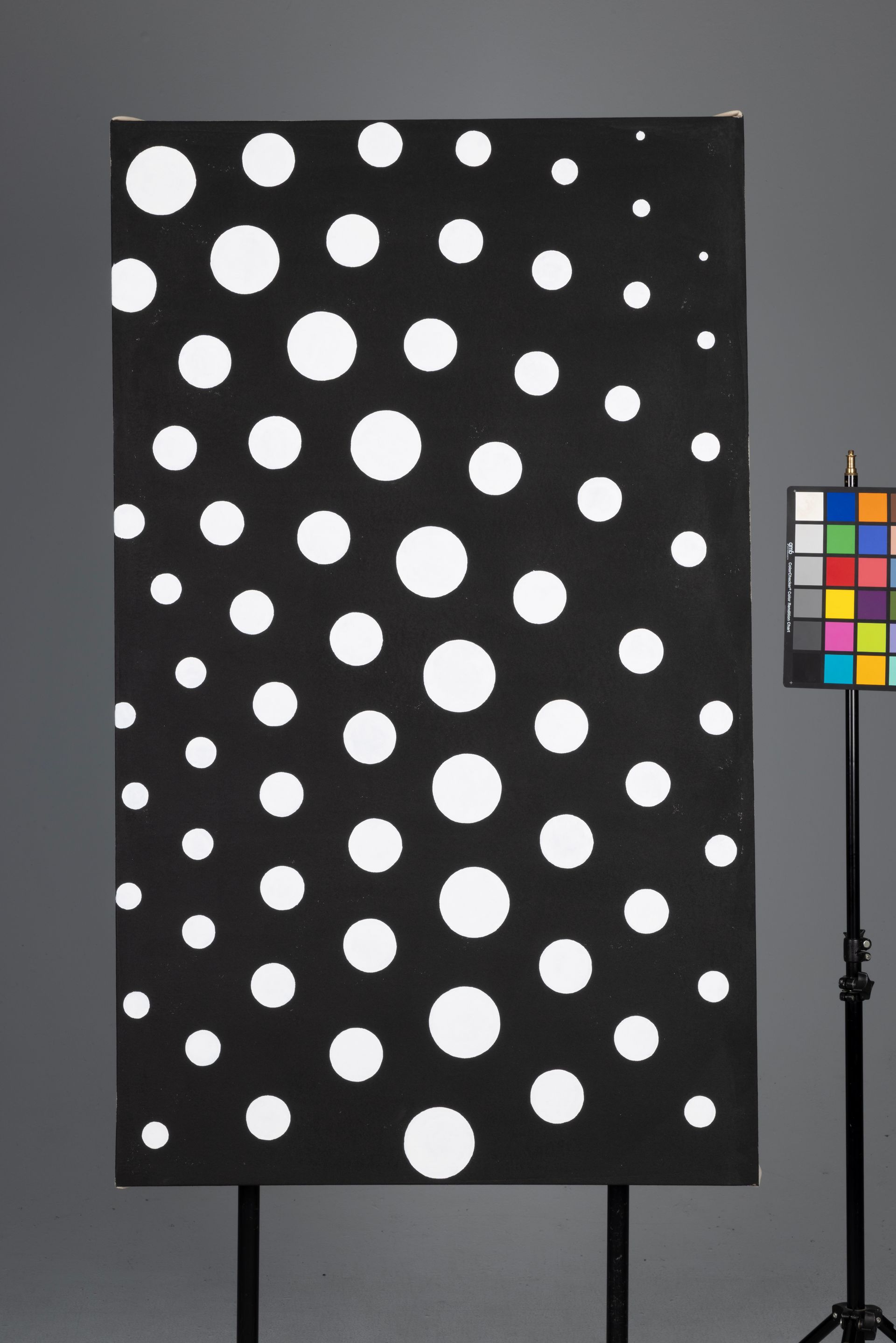 Black panel with scattered white polka dots next to a color calibration chart on a gray background