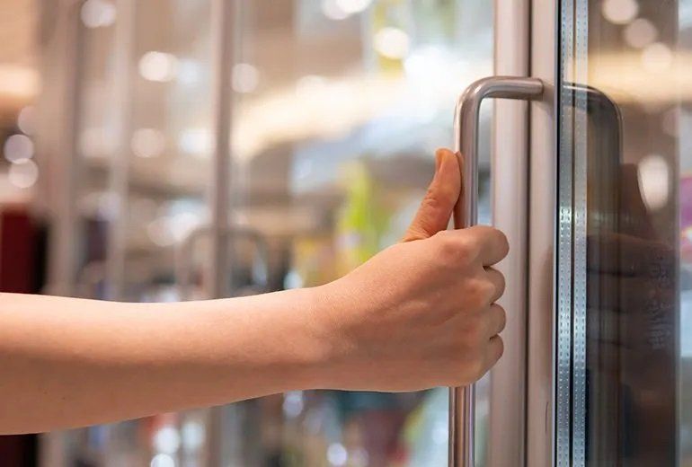 Hand holding the handle of refrigerator