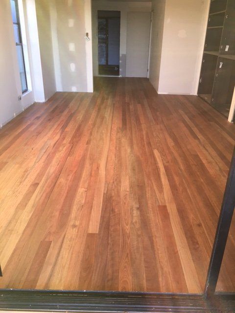 A room with a wooden floor and a sliding glass door.