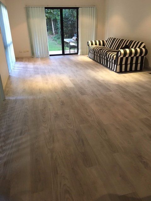 A living room with a couch and a sliding glass door.