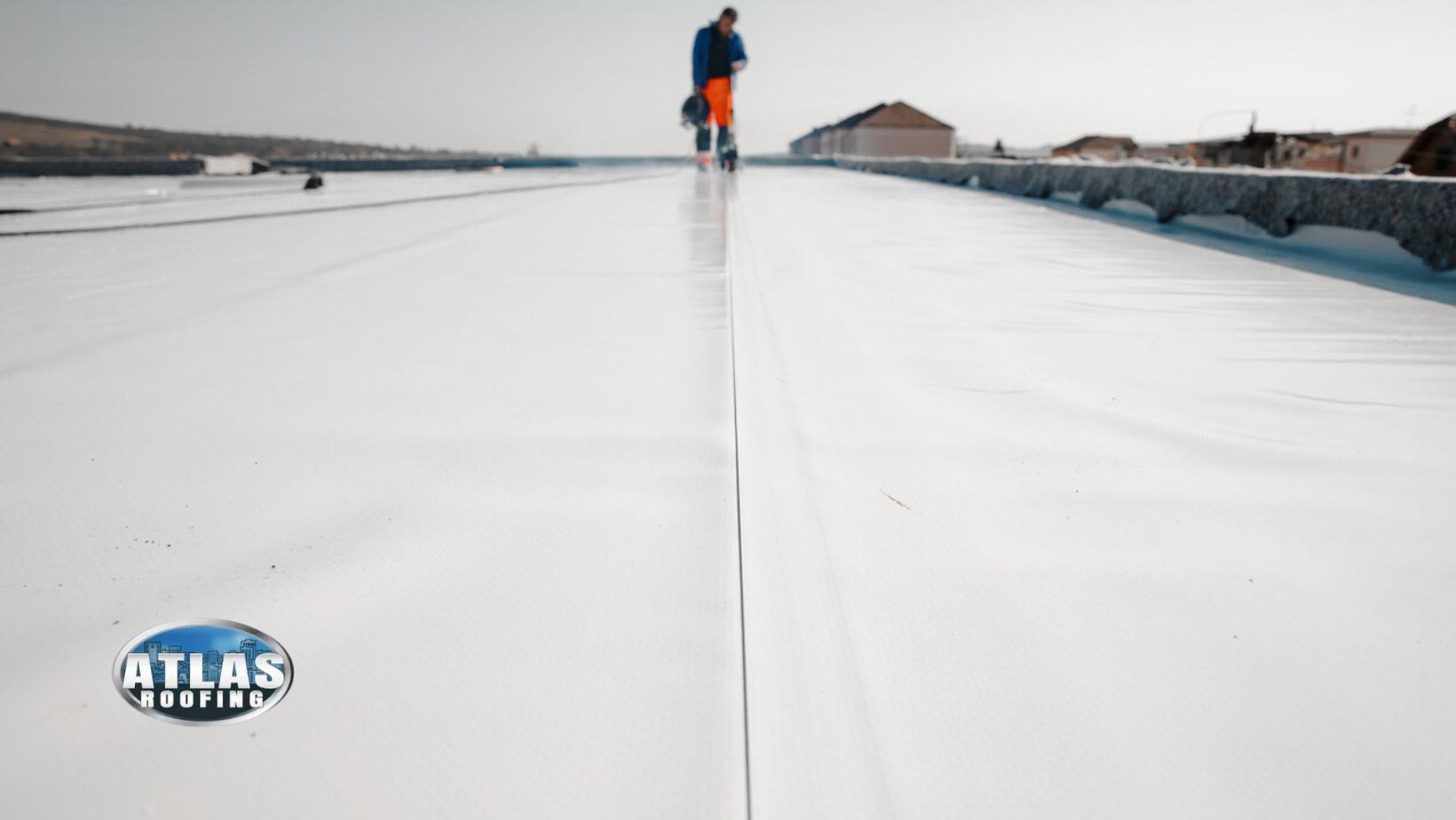 Person on white reflective roof; buildings in the background.