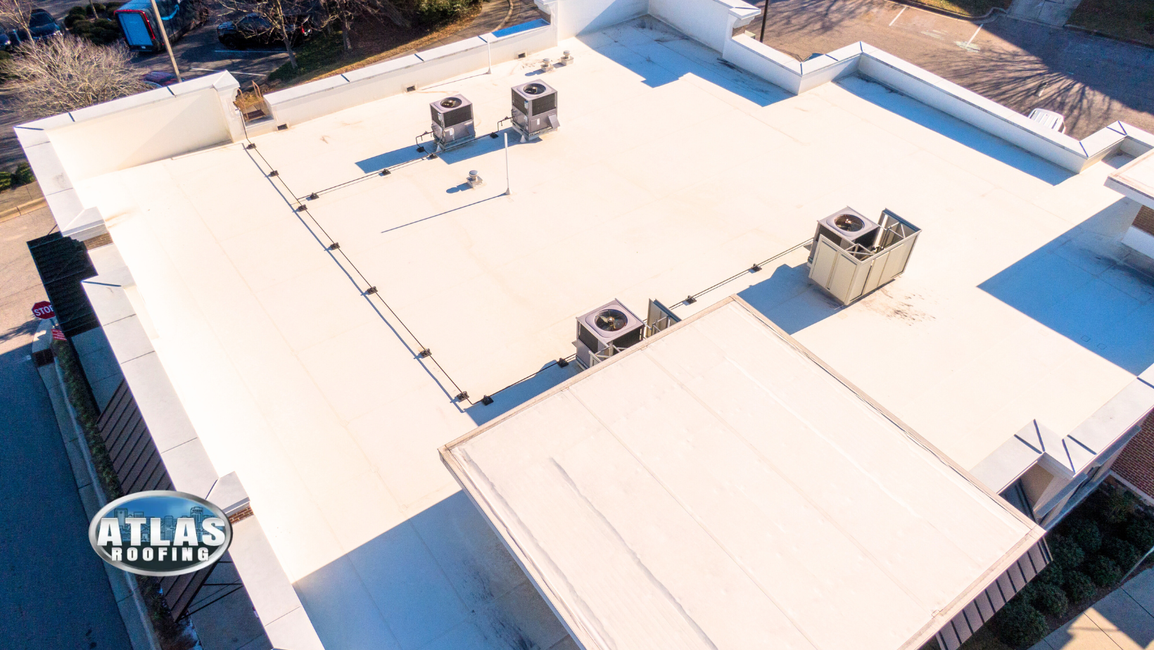 Aerial view of a white commercial flat roof with HVAC units.