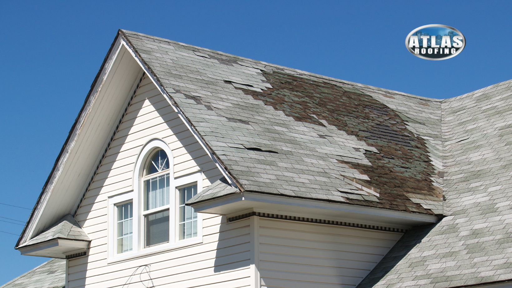 A white house with a roof that is damaged.