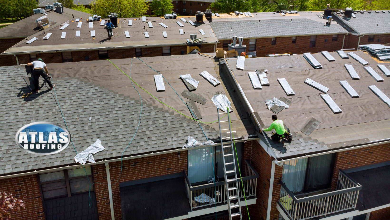 A group of people are working on the roof of a commercial building.