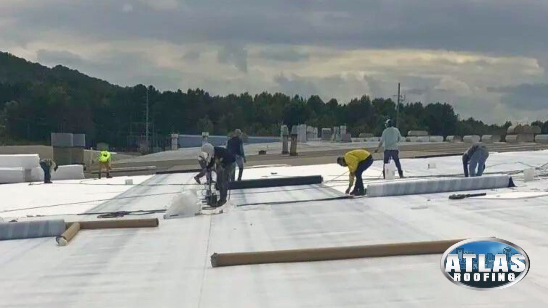 A group of people are working on a white roof.