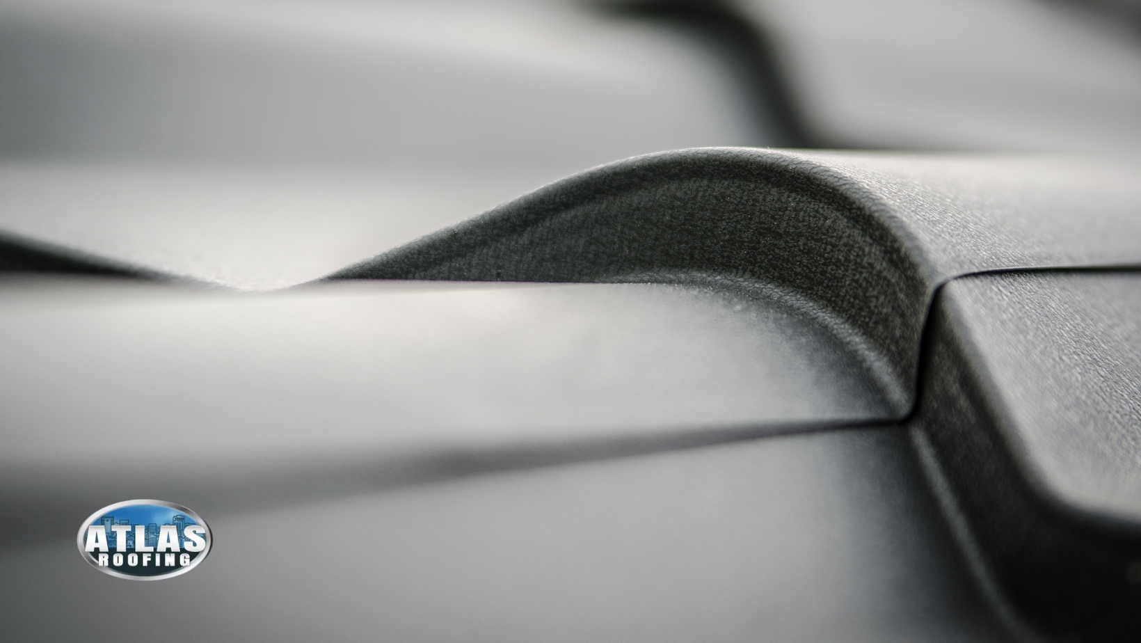 A close up of a black roof with a logo on the bottom.