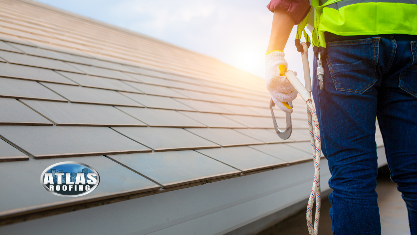 A man is standing on top of a roof holding a rope.