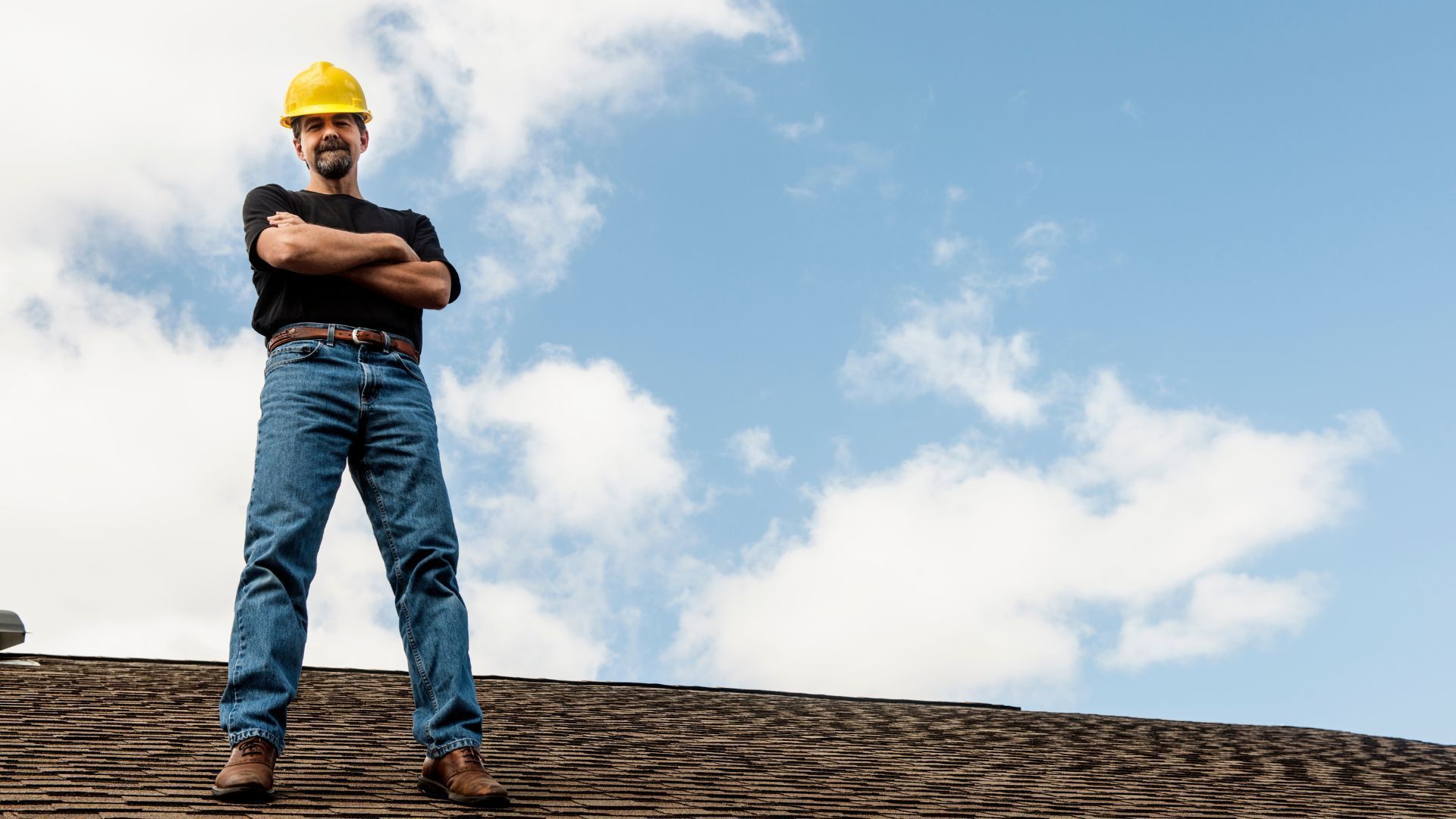 Roofer standing on residential roof