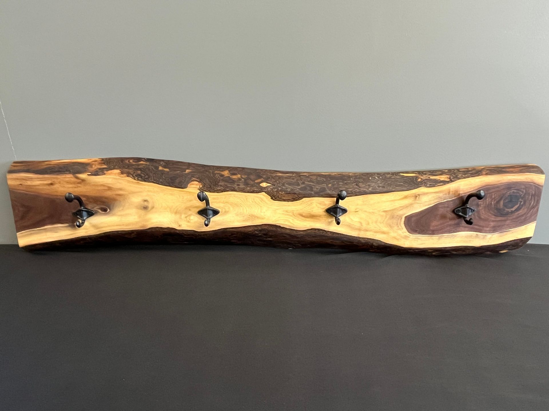 A piece of wood with hooks on it is sitting on a table.