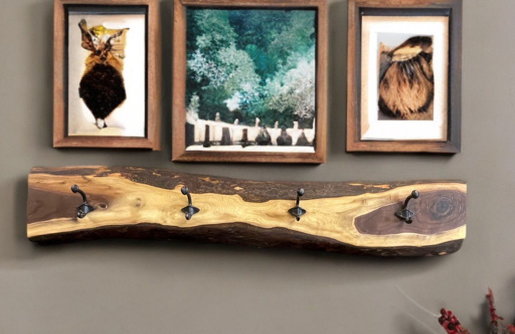 Three pictures are hanging on a wall above a wooden shelf.