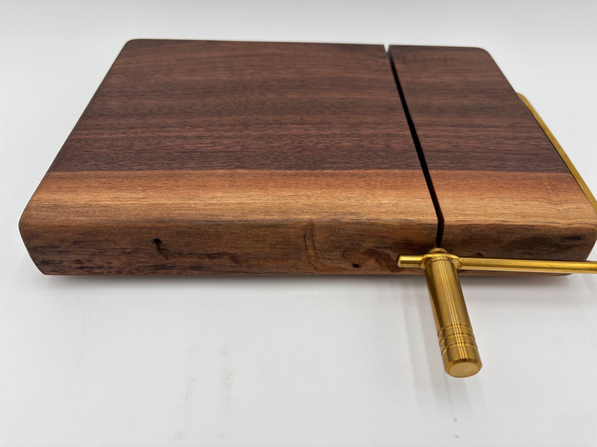Wooden cheese board with brass cutter.