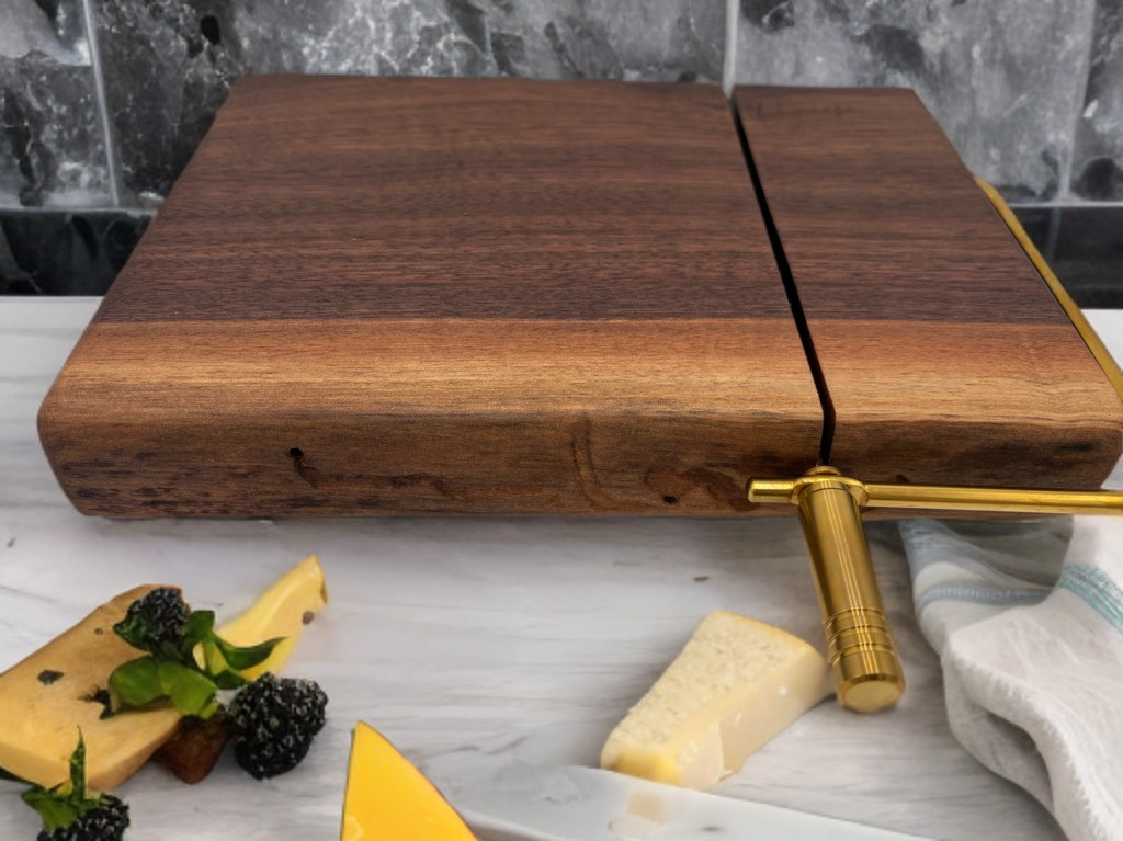 Wooden cheese board with brass slicer, cheese, and blackberries.