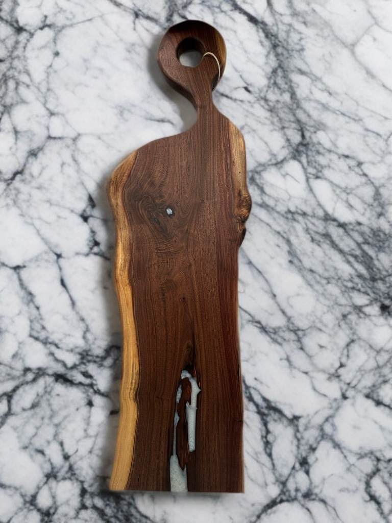 Wooden charcuterie board with natural edge and handle.