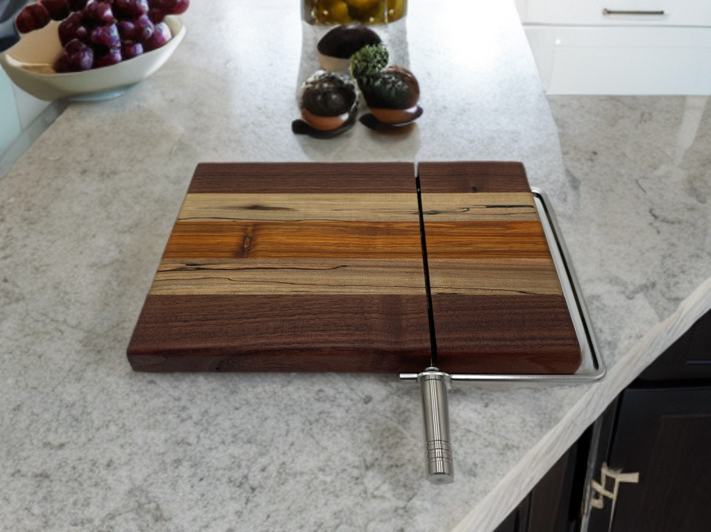 A wooden cutting board is sitting on a counter next to a bowl of grapes