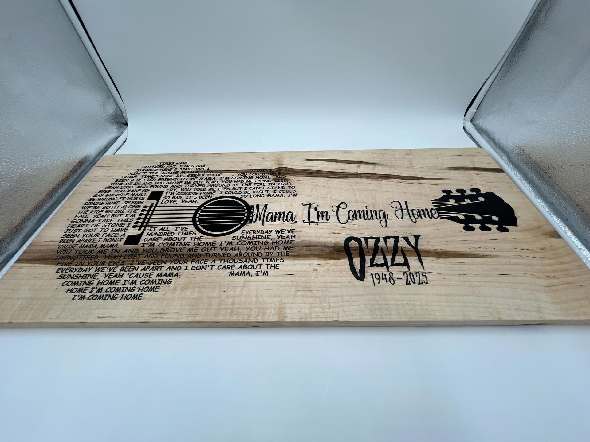 Wooden guitar art with Ozzy's name and lyrics, inside a lit photo box.