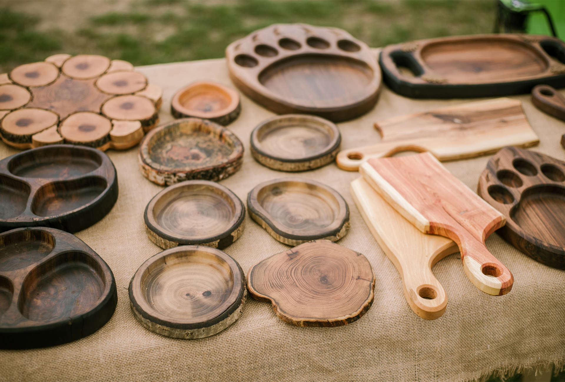 A table topped with a variety of wooden plates and cutting boards