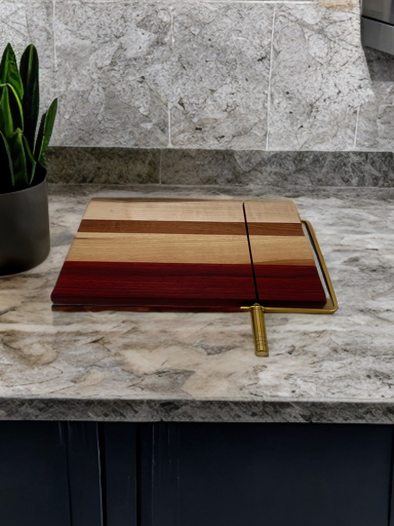 A wooden cutting board is sitting on a counter next to a potted plant.