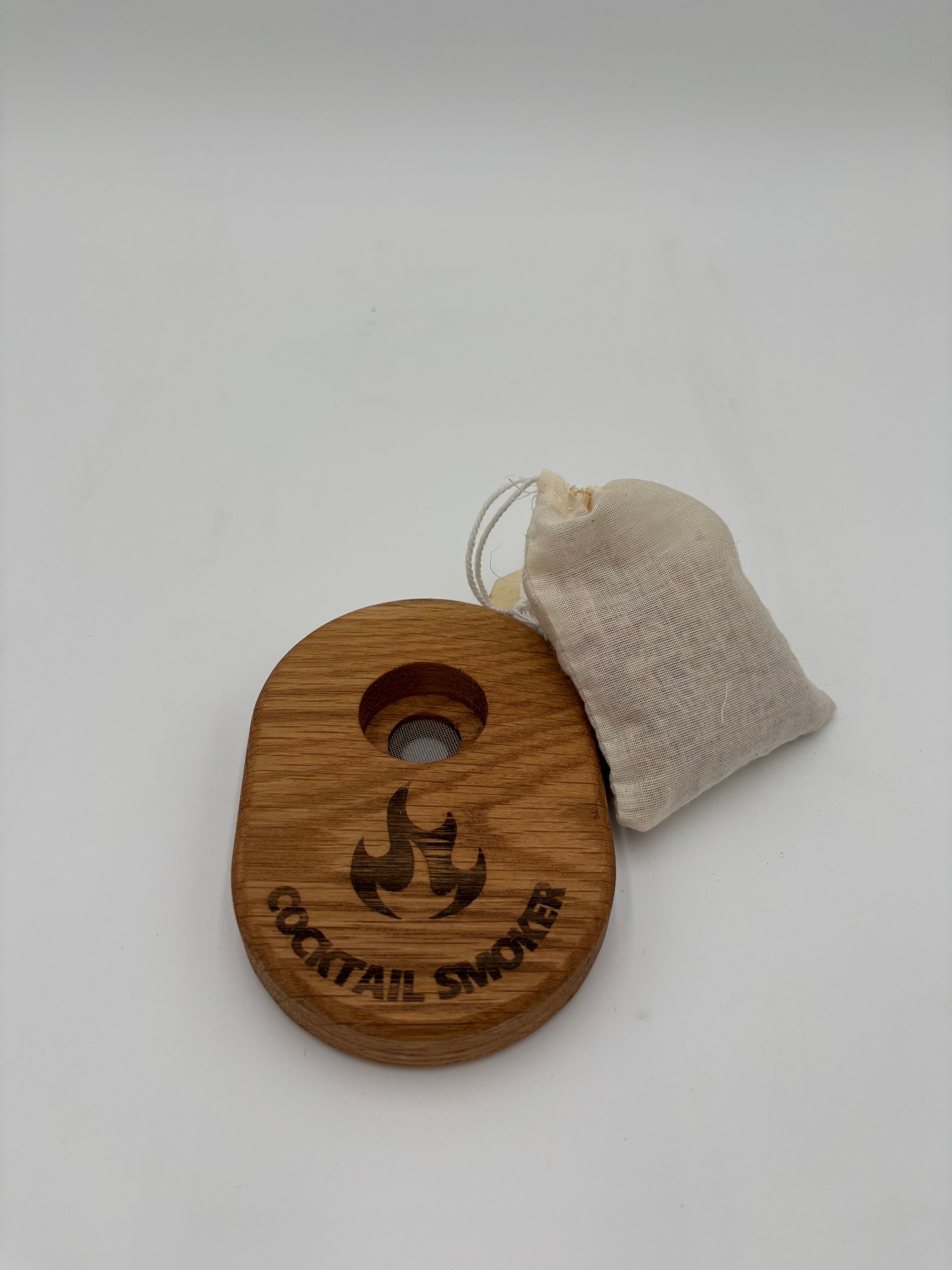 Wooden cocktail smoker with small bag, set against a white background.