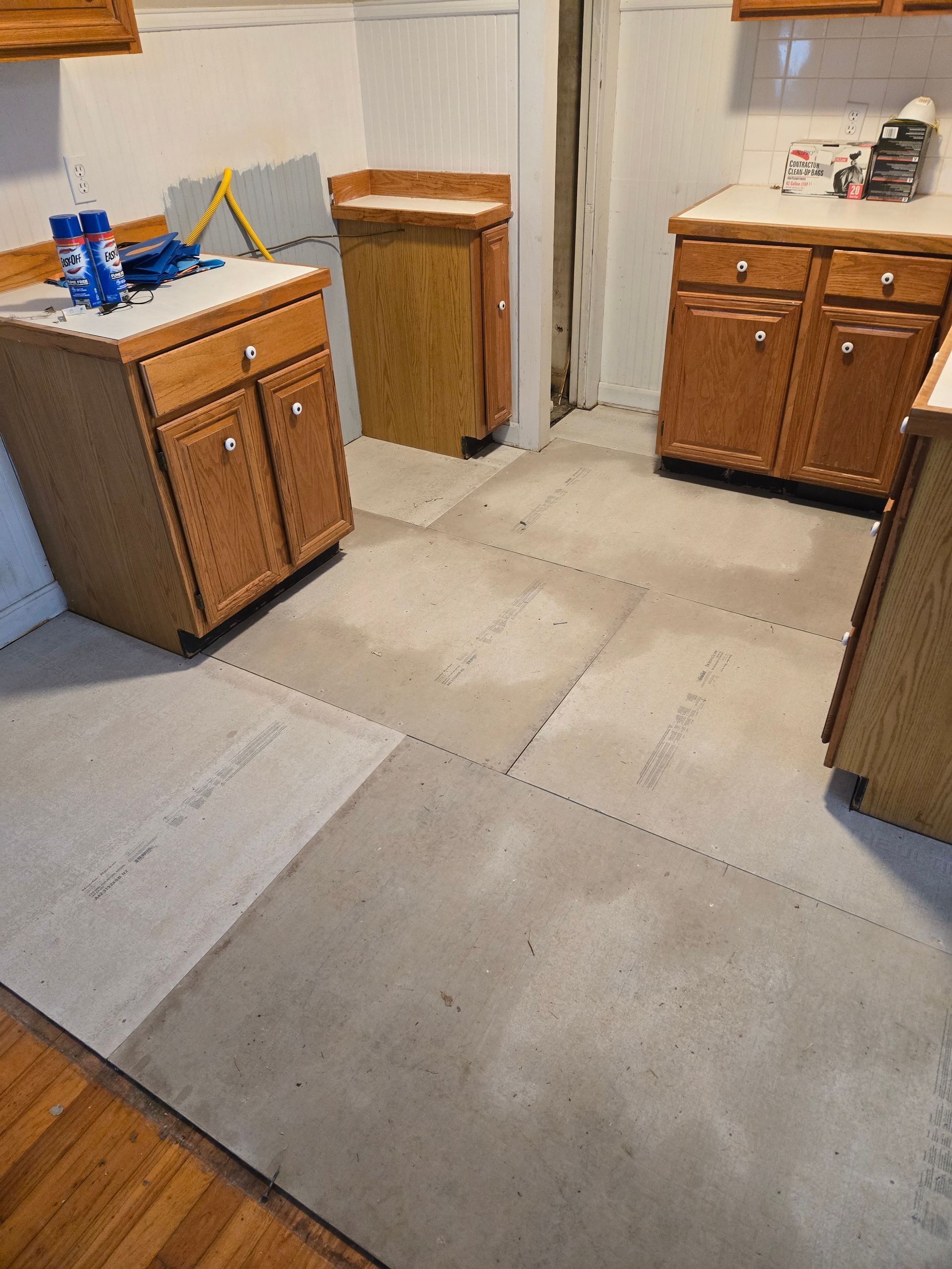 A kitchen with wooden cabinets and a concrete floor.