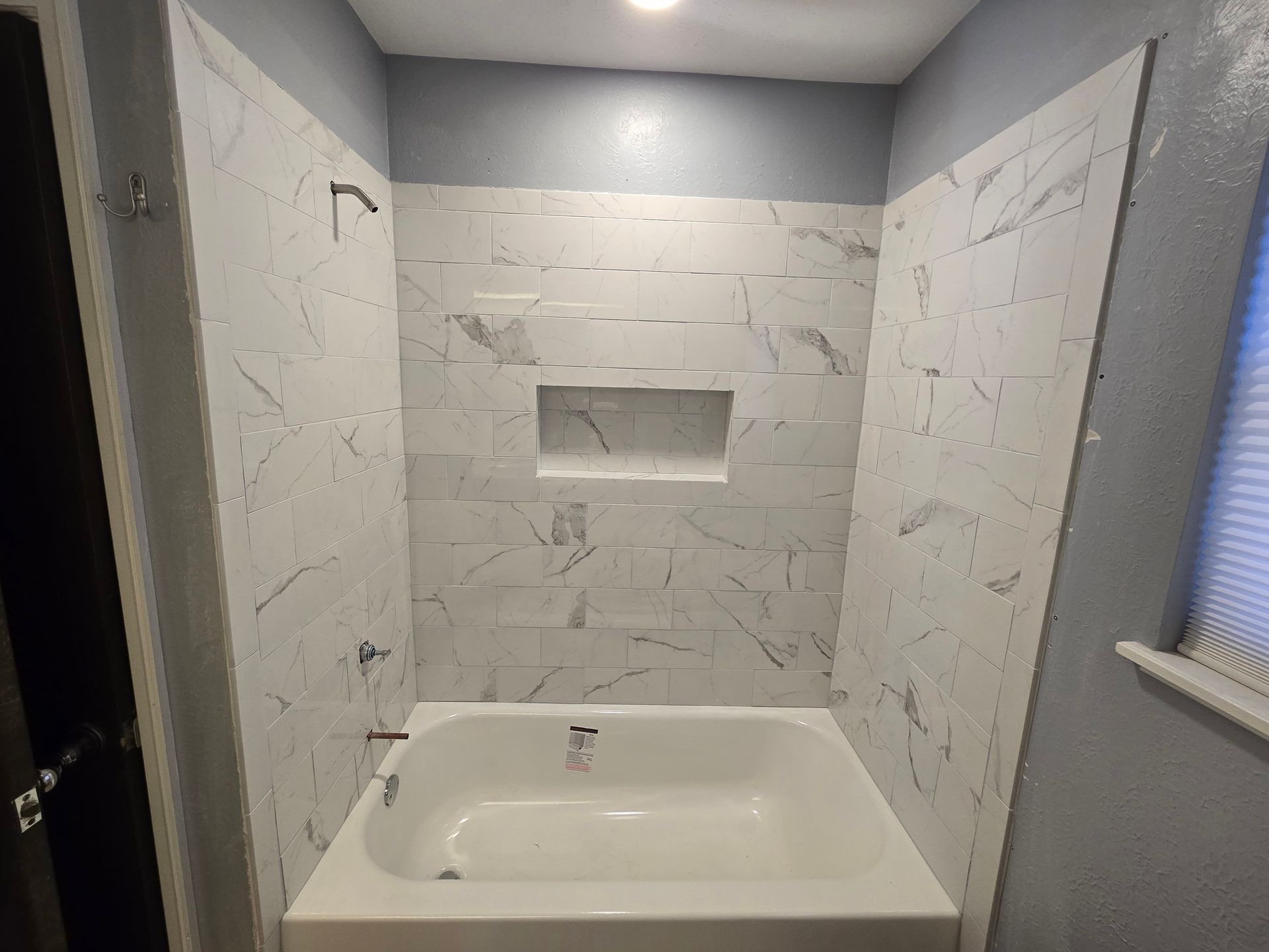 A bathroom with a bathtub and a shower stall.