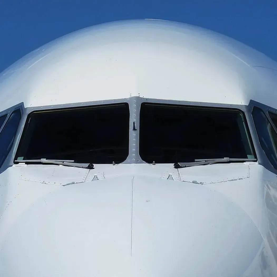 Eine Nahaufnahme des Cockpits eines Flugzeugs vor blauem Himmel