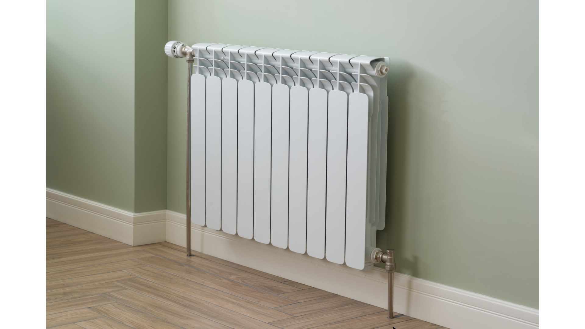 A white radiator is mounted to a wall in a room.