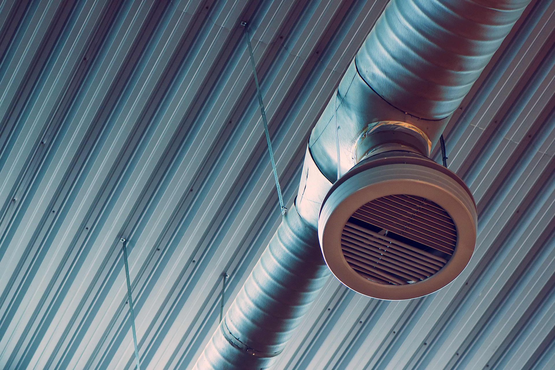 a metal pipe is hanging from the ceiling of a building .