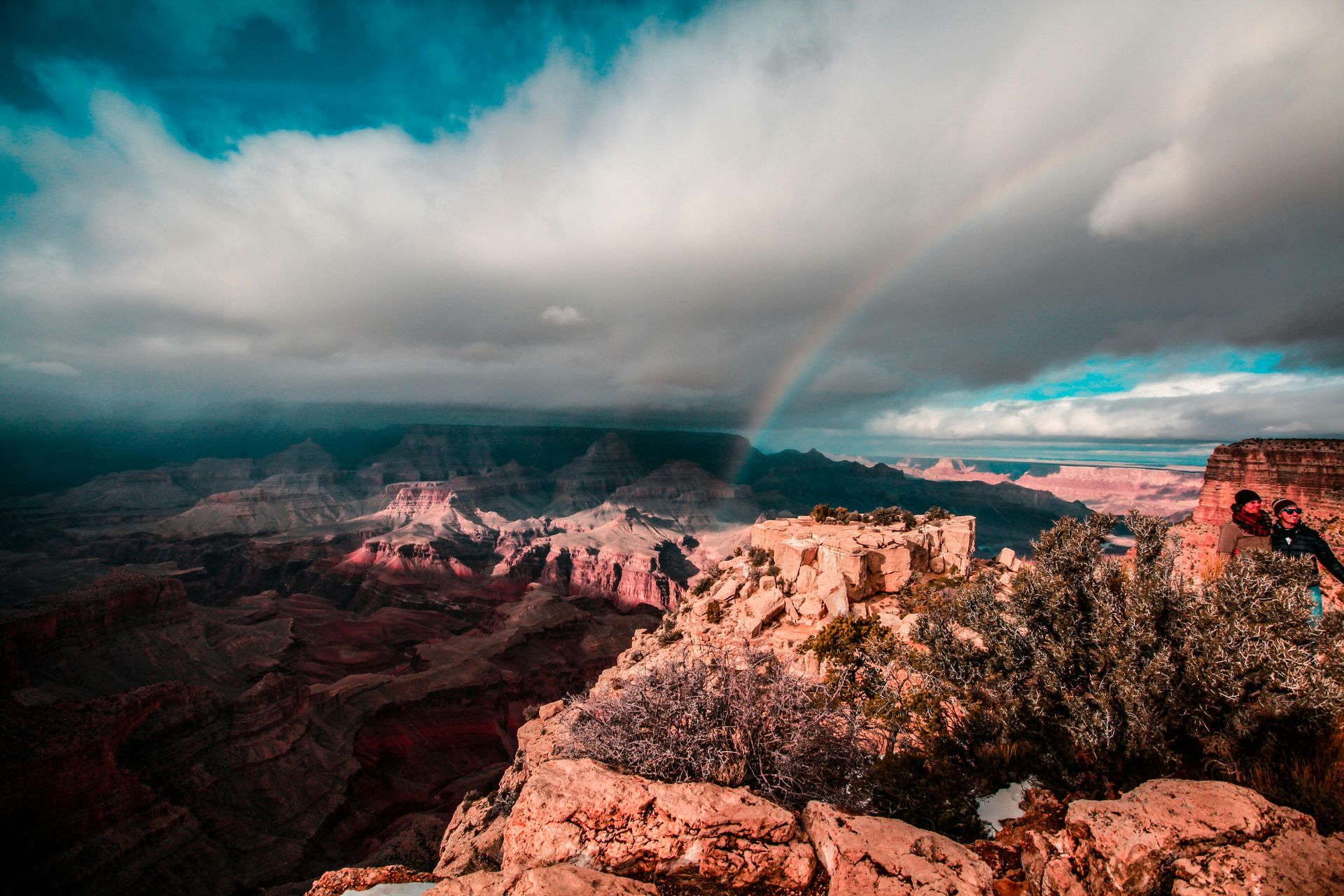 There is a rainbow in the sky over the grand canyon.