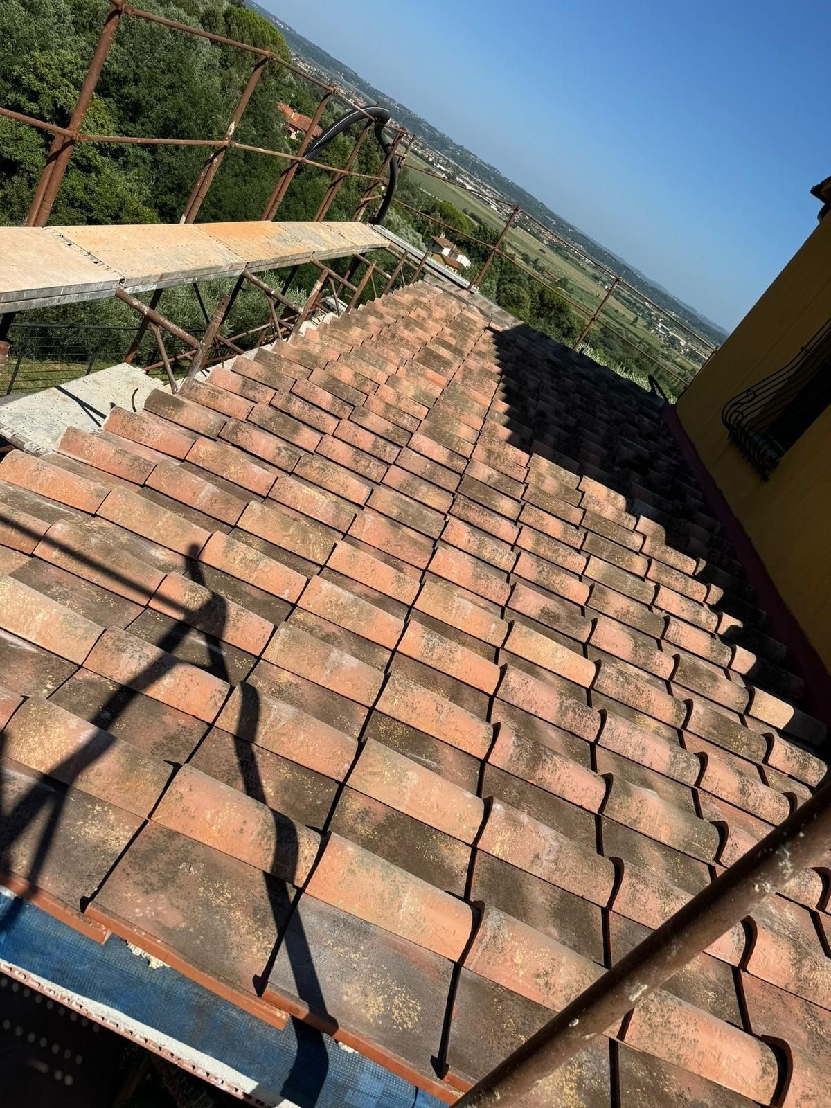 Un tetto con tante tegole e un'impalcatura sopra