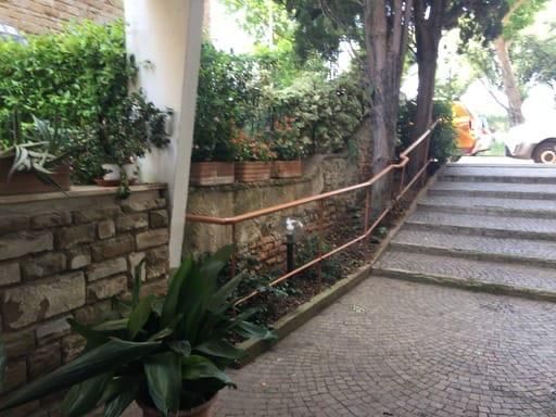 Scale che portano a un edificio con una ringhiera in rame