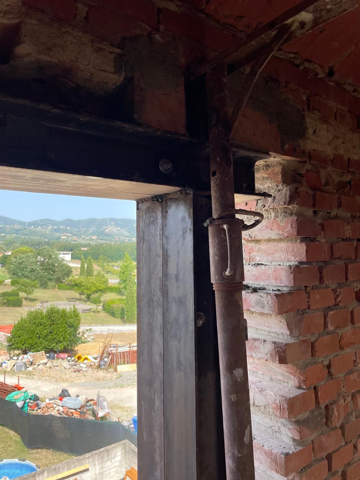 Una finestra in un edificio in mattoni con vista su un cantiere edile.