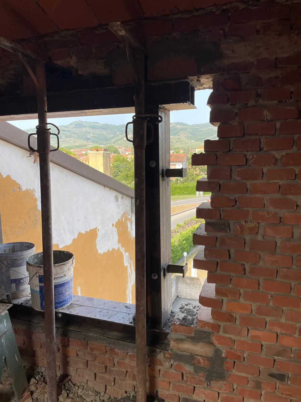 Un muro di mattoni con un buco e una finestra.