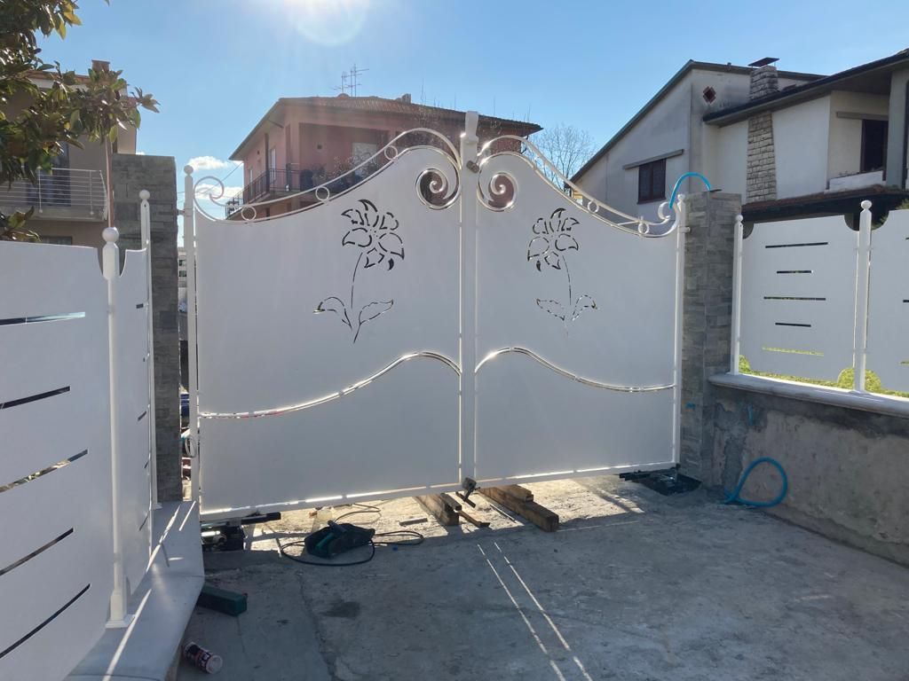 Un cancello bianco con un disegno floreale sopra