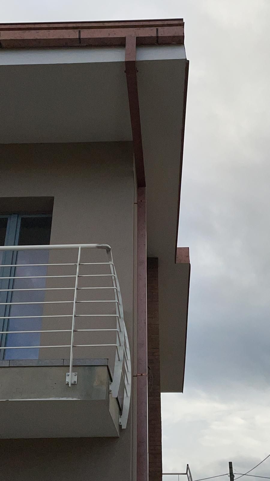 Un balcone sul lato di un edificio con un cielo nuvoloso sullo sfondo