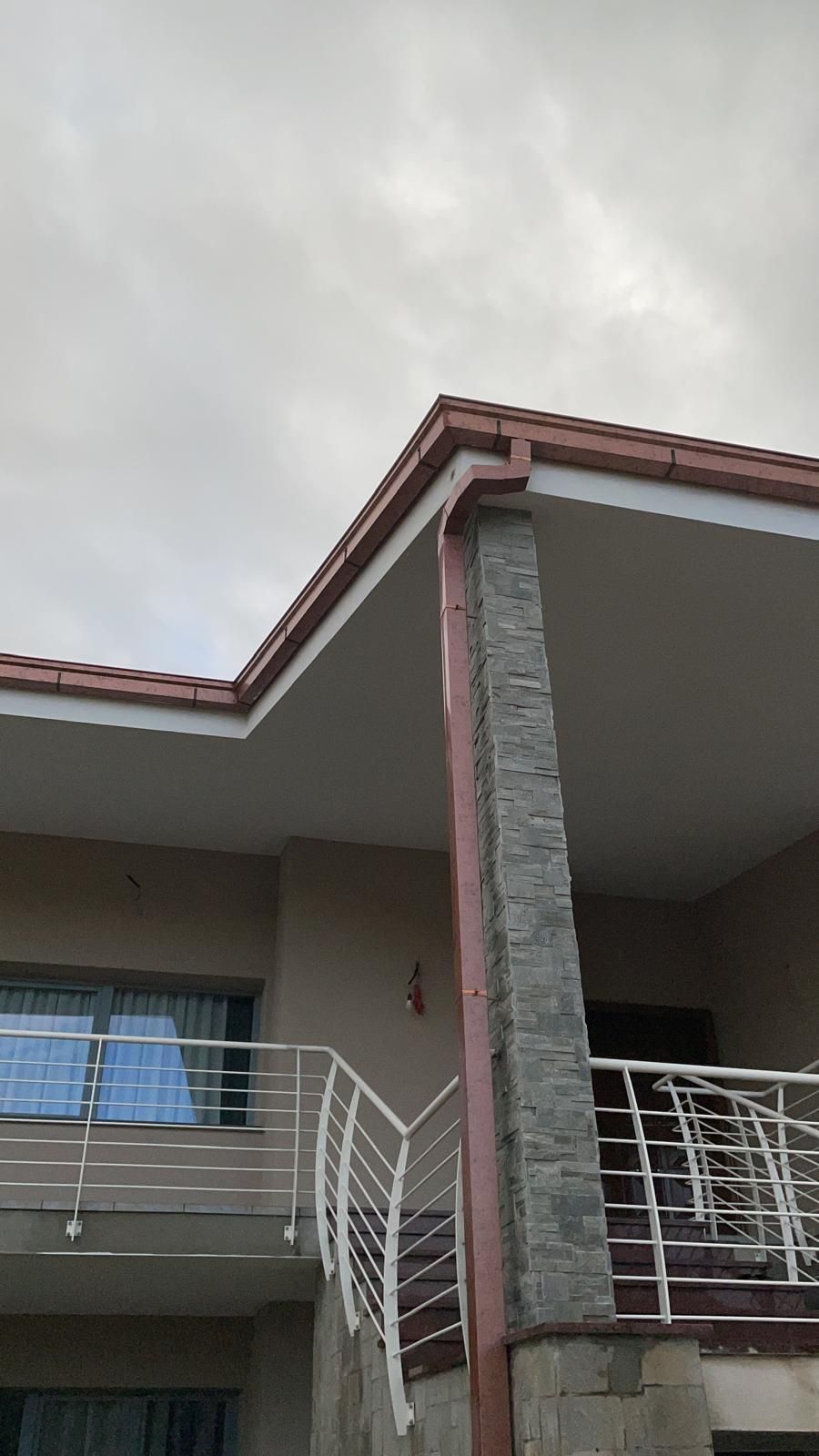 Una casa con un balcone e una grondaia sul tetto