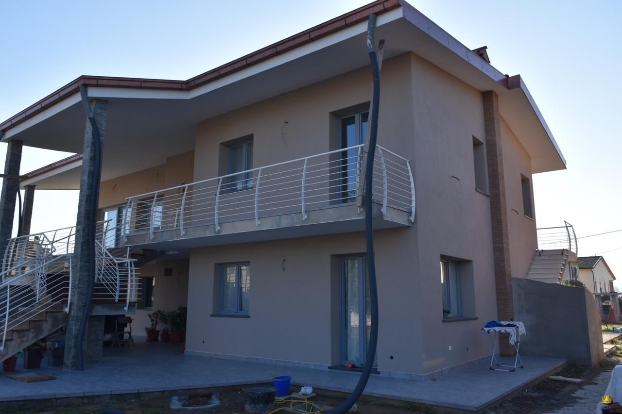 Una grande casa con balcone e scale