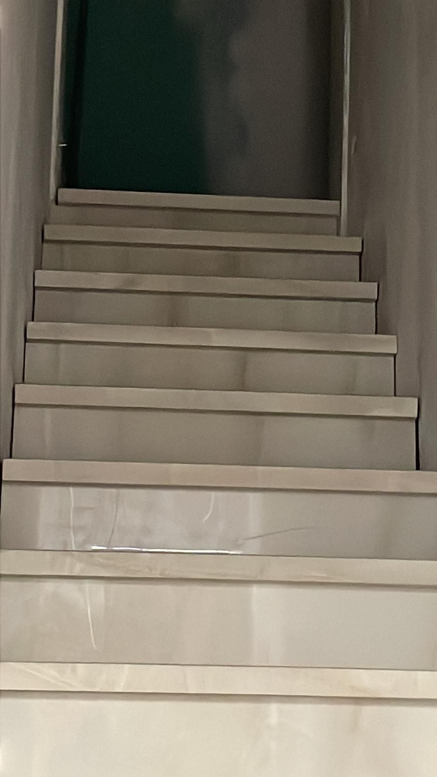 Una serie di scale bianche che portano a una porta verde.