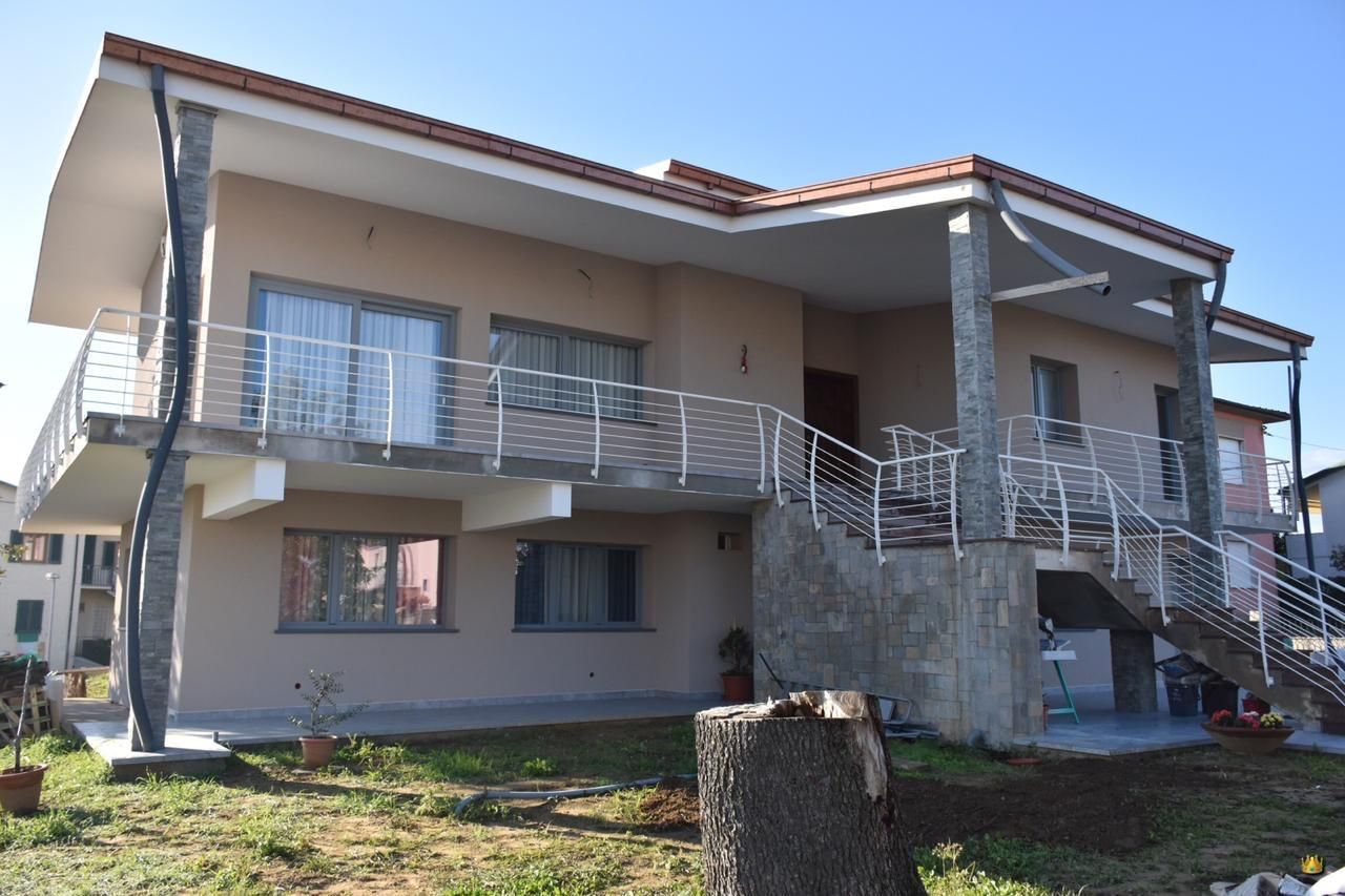 Una grande casa con un balcone e delle scale davanti.