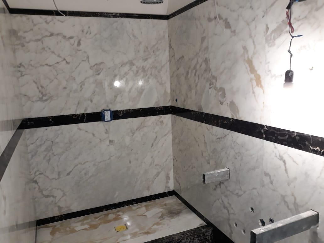 È in fase di ristrutturazione un bagno con pareti in marmo e finiture nere.