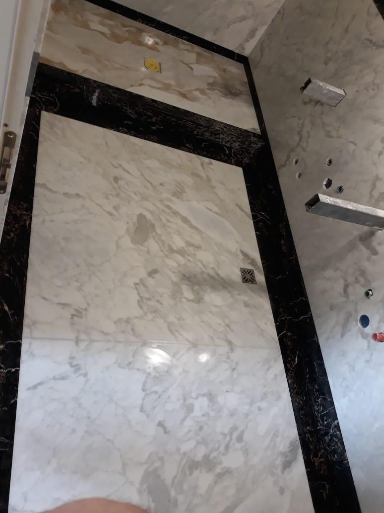 Una persona è in piedi su un pavimento di marmo con un bordo nero.