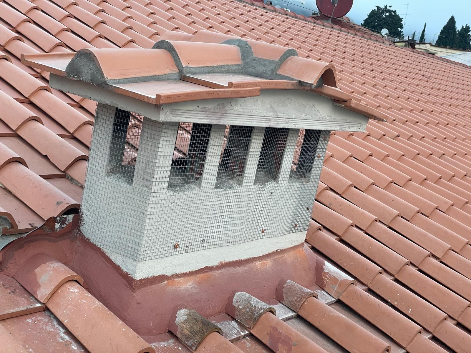 Un camino è appoggiato sopra un tetto di tegole