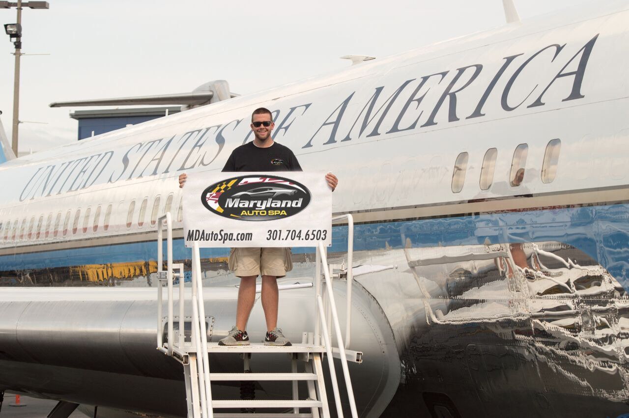A man is standing on a ladder in front of a united states of america airplane