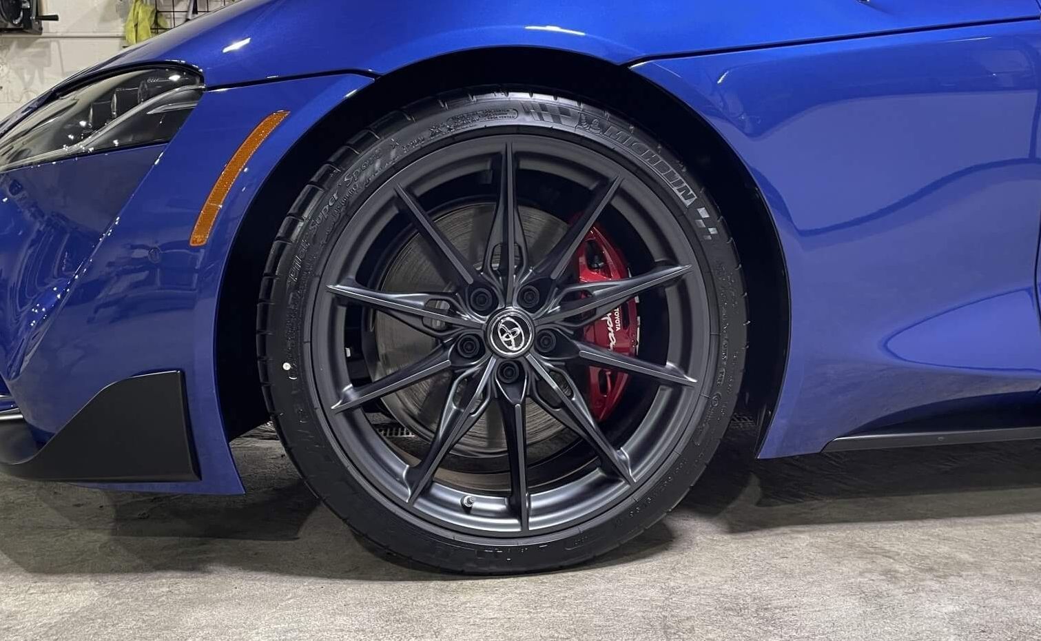 A blue sports car is parked in a garage.
