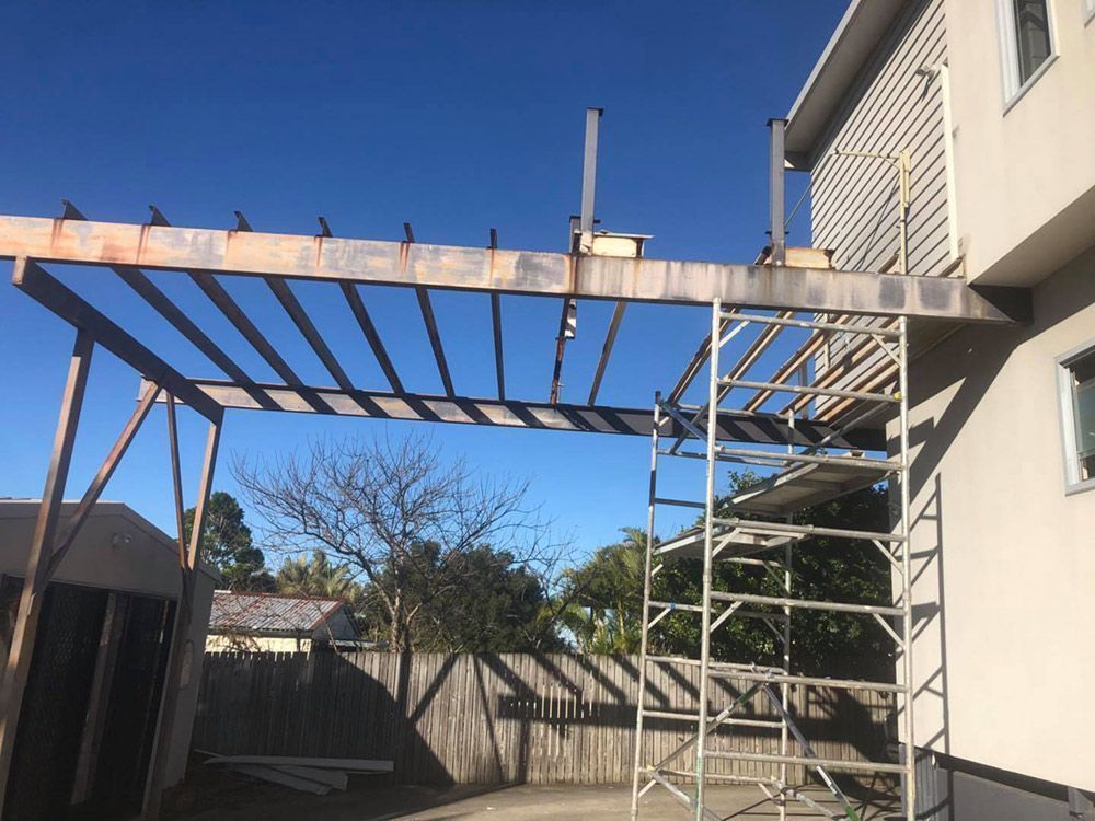 A Wooden Structure Is Being Built on The Side of A House — Polson Construction in Kedron, QLD