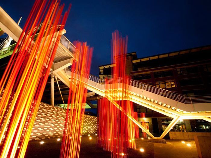 A bridge with a bunch of red sticks hanging from it
