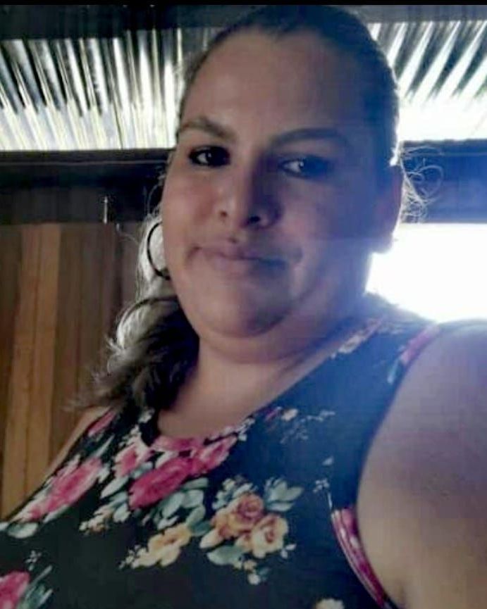 A woman in a floral dress is taking a selfie.