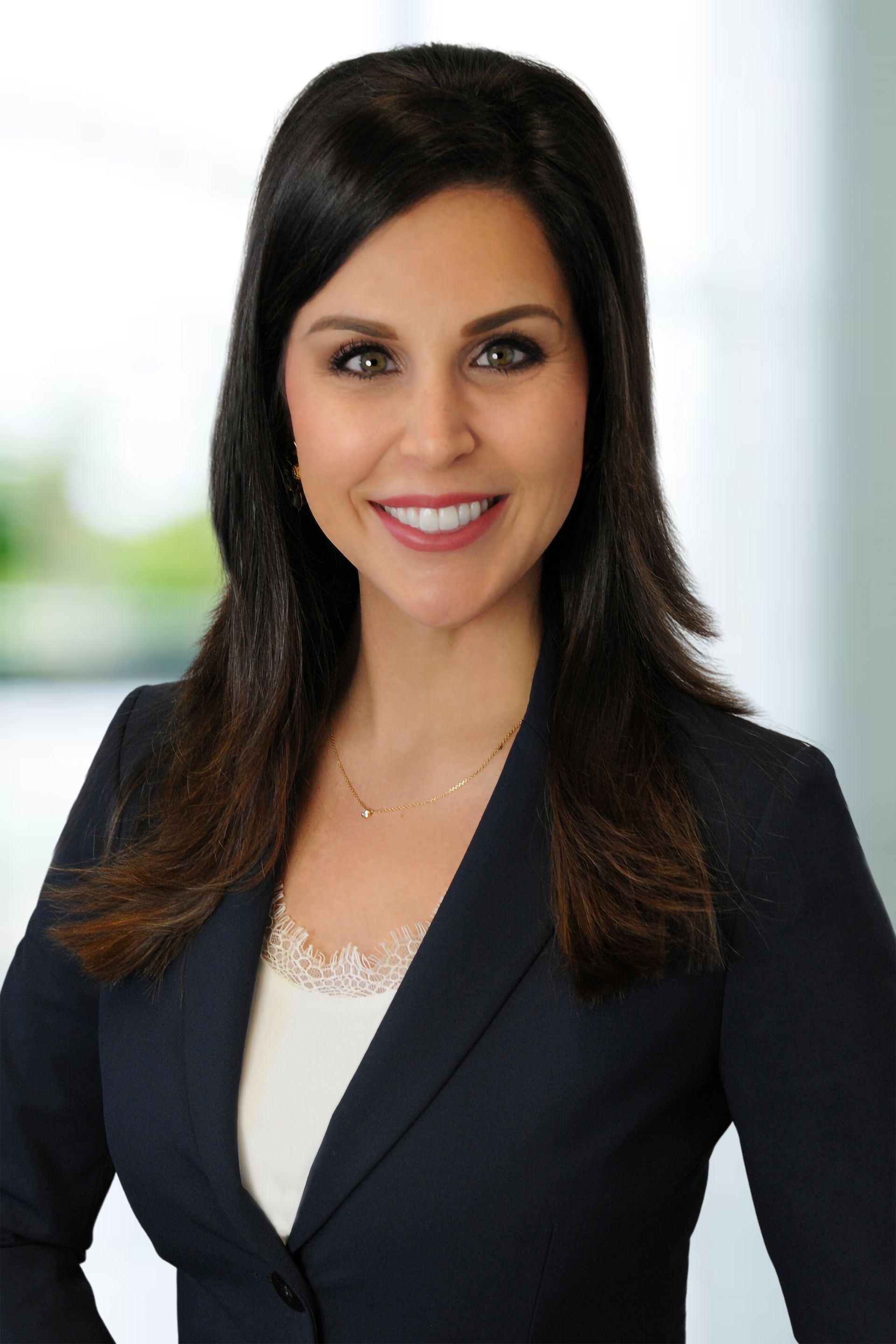A woman in a business suit is smiling for the camera