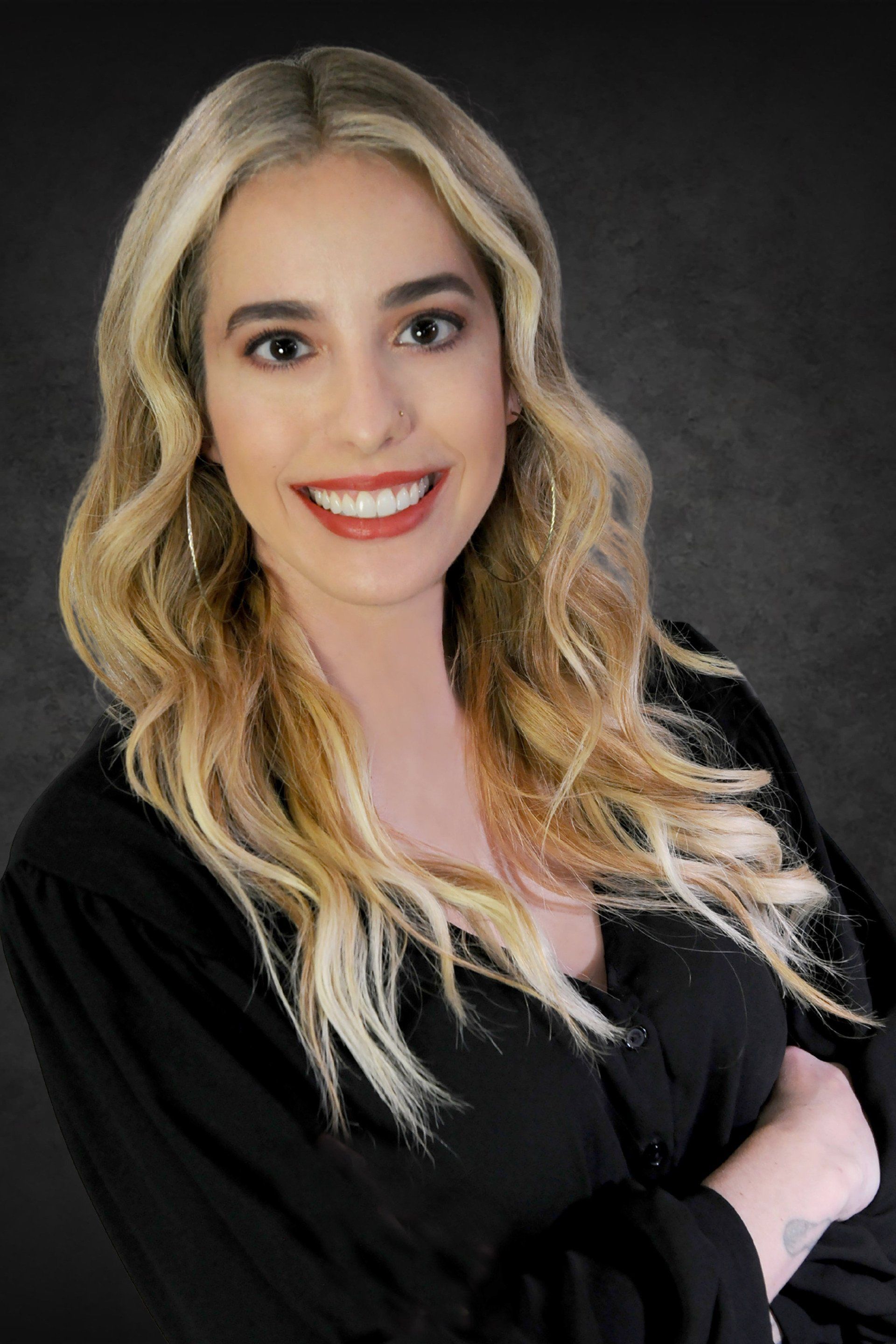 The woman is wearing a black shirt and smiling for the camera.