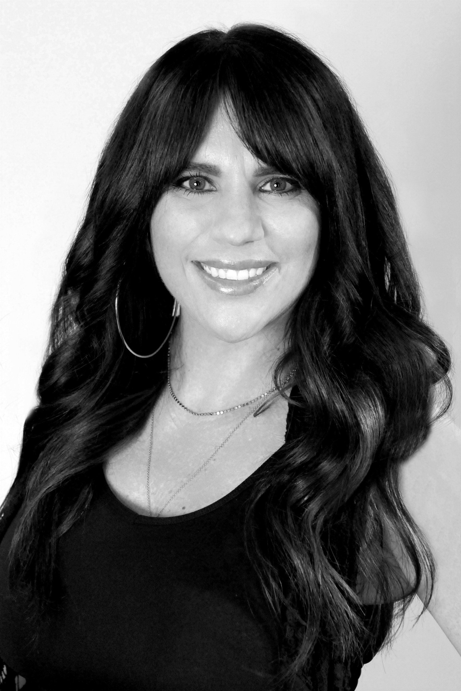 A black and white photo of a woman with long hair and bangs.